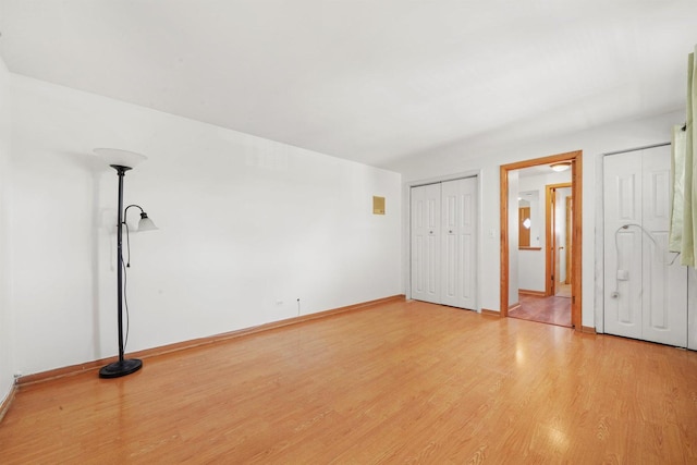 6534 N NW Hwy Unit 3D, Chicago, IL 60631 - unfurnished bedroom with light wood-style floors, baseboards, and two closets