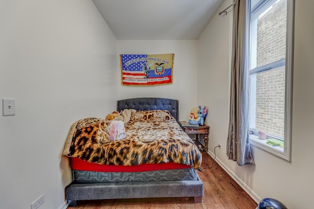 3340 W Polk St, Chicago, IL 60624 - bedroom with multiple windows, wood finished floors, and baseboards