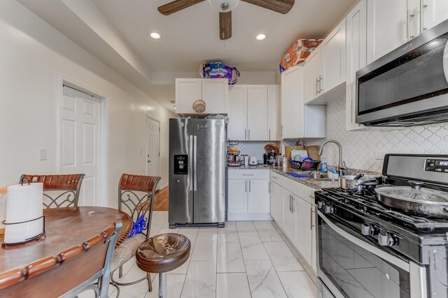 3340 W Polk St, Chicago, IL 60624 - kitchen featuring appliances with stainless steel finishes, a sink, ceiling fan, white cabinetry, and recessed lighting