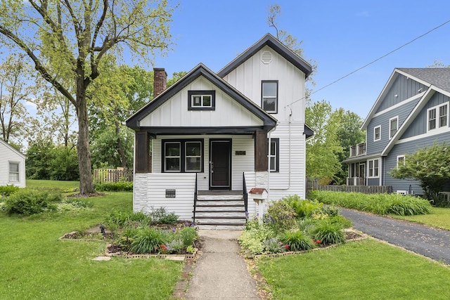 504 Newton Ave, Glen Ellyn, IL 60137 - view of front of house featuring a front lawn, a porch, a chimney, and board and batten siding