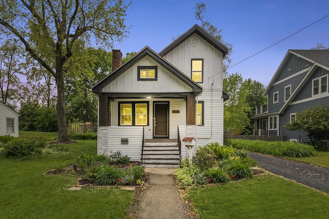 504 Newton Ave, Glen Ellyn, IL 60137 - view of front of house featuring a chimney, a porch, a lawn, and board and batten siding