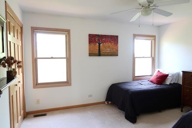 957 Chancery Ln, Cary, IL 60013 - bedroom featuring light carpet, baseboards, and ceiling fan