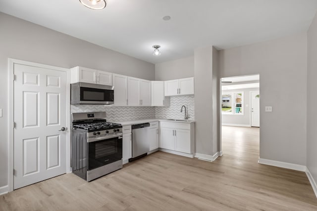 1729 S Hamilton St, Lockport, IL 60441 - kitchen with stainless steel appliances, a sink, white cabinets, decorative backsplash, and light wood-type flooring