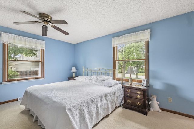 1720 Brookhill Ln, Sycamore, IL 60178 - carpeted bedroom featuring multiple windows, baseboards, ceiling fan, and a textured ceiling