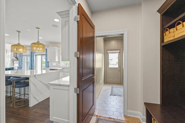 4328 Chinaberry Ln, Naperville, IL 60564 - kitchen featuring a sink, white cabinets, light stone countertops, a center island, and pendant lighting