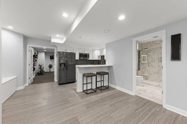 4328 Chinaberry Ln, Naperville, IL 60564 - kitchen featuring black fridge with ice dispenser, stainless steel microwave, white cabinetry, recessed lighting, and a peninsula