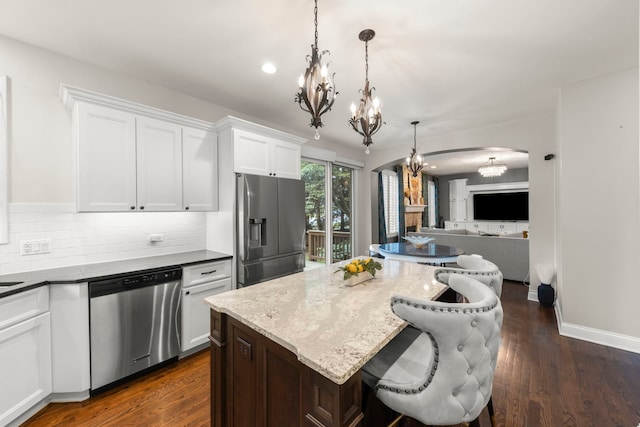 1728 Elyse Ln, Naperville, IL 60565 - kitchen featuring appliances with stainless steel finishes, a chandelier, a kitchen island, arched walkways, and white cabinets