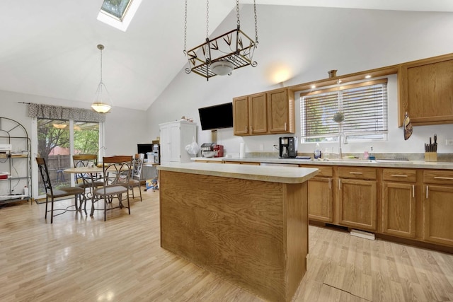 1499 Raven Dr, Bolingbrook, IL 60490 - kitchen with high vaulted ceiling, a skylight, a sink, light wood-type flooring, and brown cabinetry