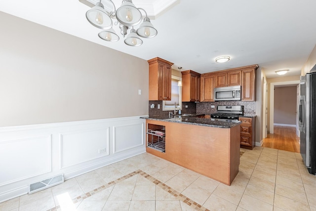 7817 Menard Ave, Burbank, IL 60459 - kitchen featuring stainless steel appliances, a chandelier, a peninsula, a sink, and light tile patterned flooring