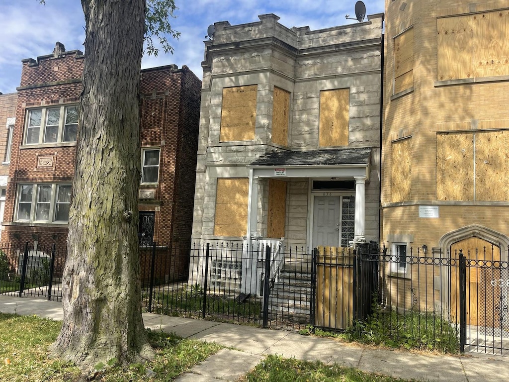636 N St Louis Ave, Chicago, IL 60624 - view of front of house with a fenced front yard, stone siding, and a gate