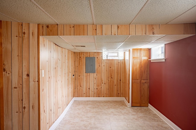 14207 Concord Dr, Orland Park, IL 60462 - basement with a drop ceiling, wooden walls, electric panel, and baseboards