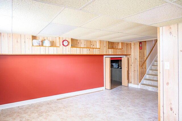 14207 Concord Dr, Orland Park, IL 60462 - finished below grade area with a paneled ceiling, wooden walls, stairs, and baseboards