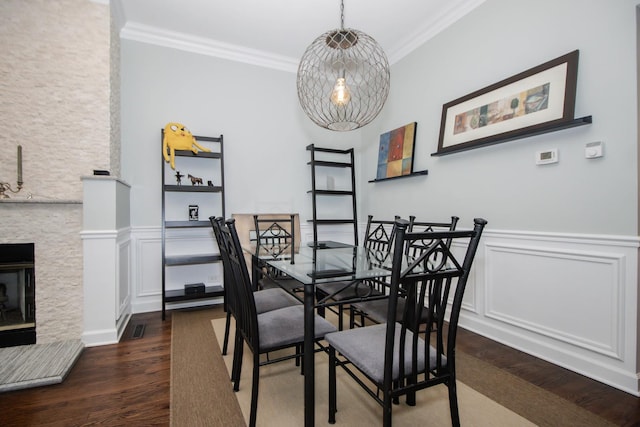 235 S Marion St Unit C, Oak Park, IL 60302 - dining area with dark wood-style flooring, ornamental molding, wainscoting, a decorative wall, and a stone fireplace