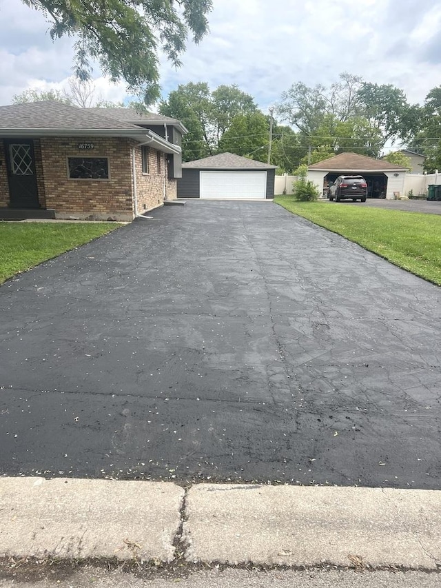 16759 Forest View Dr, Tinley Park, IL 60477 - view of side of home with brick siding, a detached garage, and a yard