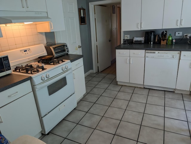 3233 S Morgan St, Chicago, IL 60608 - kitchen with white appliances, under cabinet range hood, white cabinets, light tile patterned floors, and dark countertops