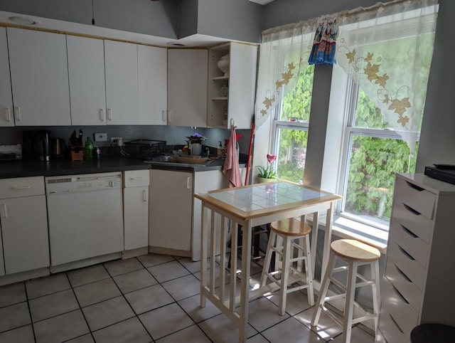 3233 S Morgan St, Chicago, IL 60608 - kitchen featuring white dishwasher, a sink, light tile patterned floors, and plenty of natural light