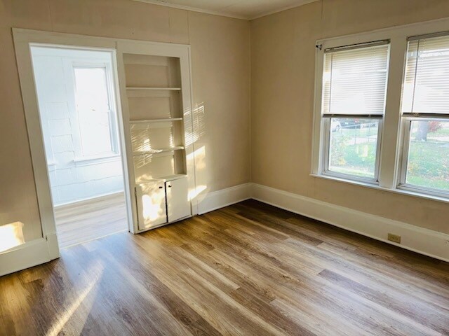 259 N Evergreen Ave, Kankakee, IL 60901 - unfurnished room with wood finished floors, crown molding, and baseboards