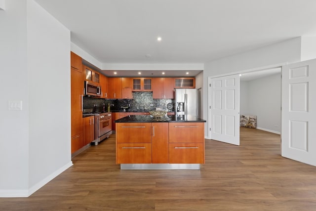 1250 S Indiana Ave Unit 1301, Chicago, IL 60605 - kitchen featuring appliances with stainless steel finishes, dark countertops, backsplash, glass insert cabinets, and a center island