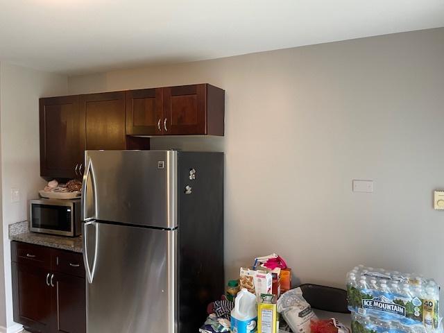 160 Dunteman Dr Unit 201, Glendale Heights, IL 60139 - kitchen featuring appliances with stainless steel finishes, dark brown cabinetry, and light stone counters