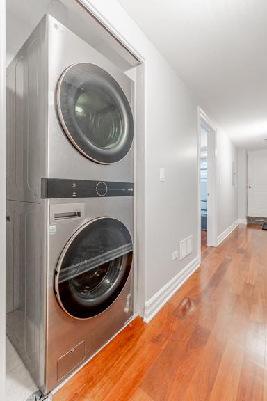 4111 N Kenmore Ave Unit 1Ng, Chicago, IL 60613 - laundry area with stacked washer / drying machine, wood finished floors, and baseboards