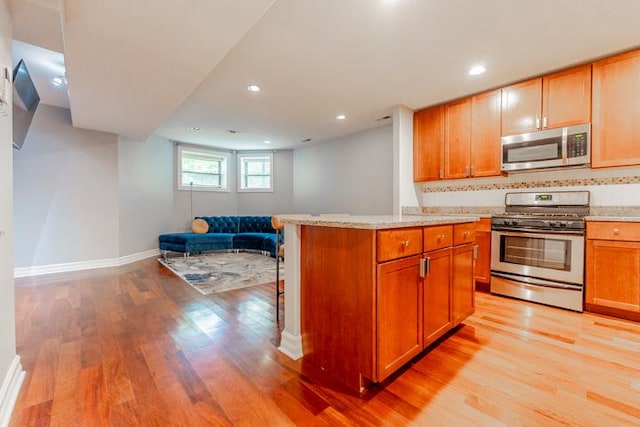 4111 N Kenmore Ave Unit 1Ng, Chicago, IL 60613 - kitchen featuring stainless steel appliances, light wood-style floors, open floor plan, baseboards, and backsplash