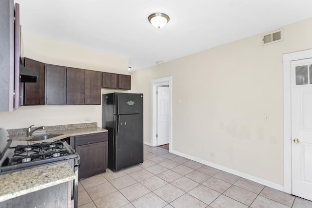4130 W Potomac Ave, Chicago, IL 60651 - kitchen featuring freestanding refrigerator, gas stove, dark brown cabinets, light tile patterned floors, and a sink