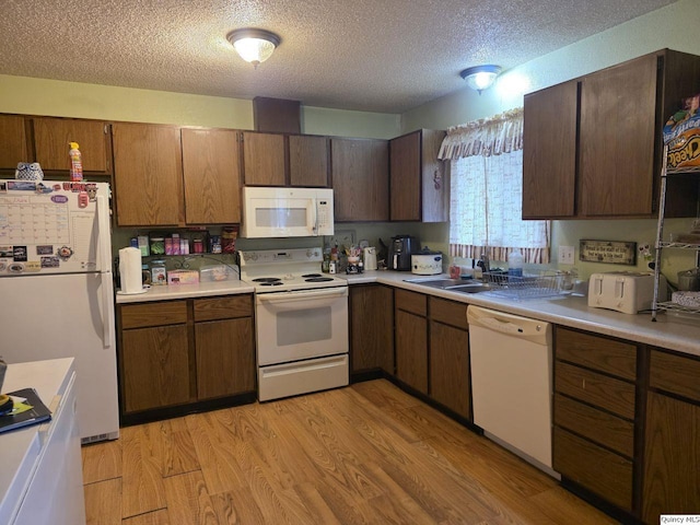 470 Alvord, Hamilton, IL 62341 - kitchen featuring white appliances, a textured ceiling, light countertops, and light wood-style floors