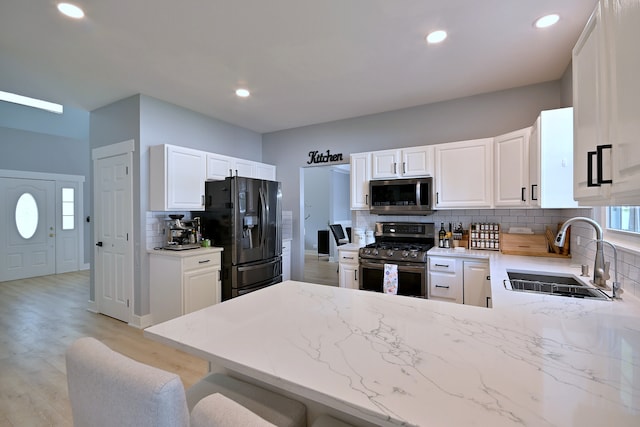 1422 Deer Creek Ln, Lake In The Hills, IL 60156 - kitchen featuring stainless steel appliances, a sink, backsplash, light stone countertops, and a peninsula