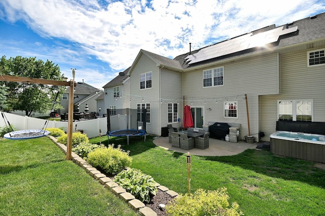 1422 Deer Creek Ln, Lake In The Hills, IL 60156 - rear view of property featuring a hot tub, a trampoline, a patio area, and roof mounted solar panels