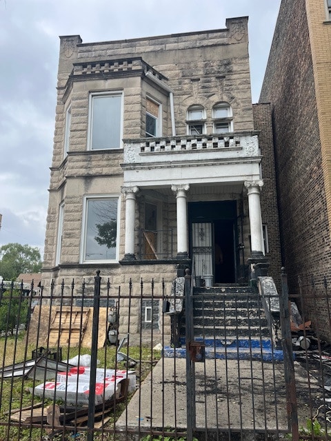 3356 W Douglas Blvd, Chicago, IL 60623 - view of front of house featuring stone siding, covered porch, a fenced front yard, and a gate