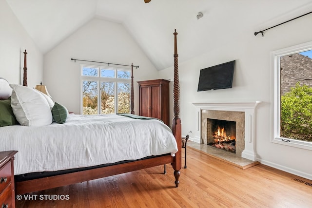 1181 Midwest Ln, Wheaton, IL 60189 - bedroom featuring multiple windows, wood finished floors, lofted ceiling, and a lit fireplace