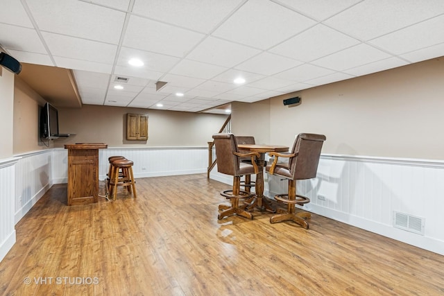 1181 Midwest Ln, Wheaton, IL 60189 - dining area with wainscoting, light wood-style flooring, a dry bar, a drop ceiling, and a decorative wall