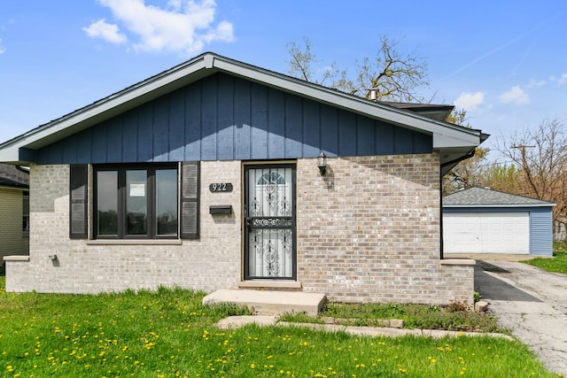 922 E 155th St, Phoenix, IL 60426 - view of front of house featuring brick siding, an outdoor structure, a detached garage, and a front yard