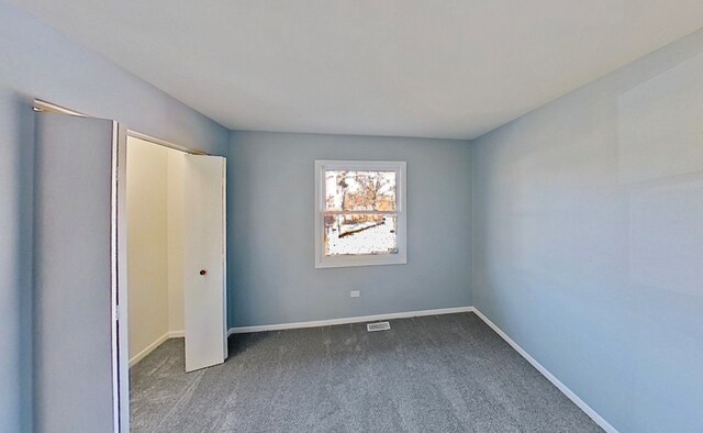 922 E 155th St, Phoenix, IL 60426 - unfurnished bedroom featuring dark colored carpet, baseboards, and a closet