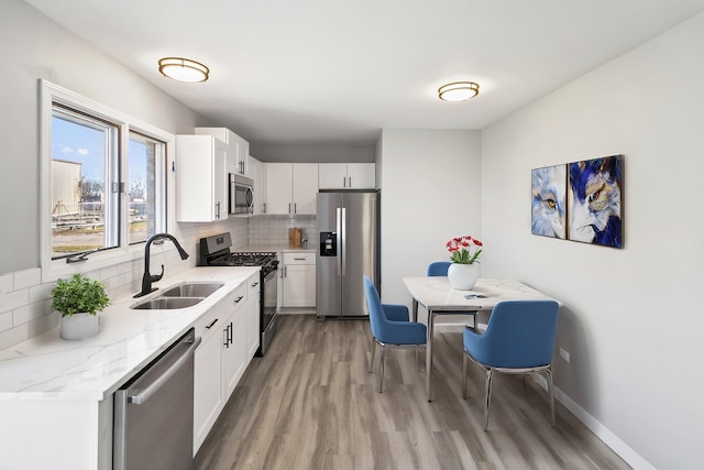 922 E 155th St, Phoenix, IL 60426 - kitchen with stainless steel appliances, a sink, light wood-style flooring, and decorative backsplash
