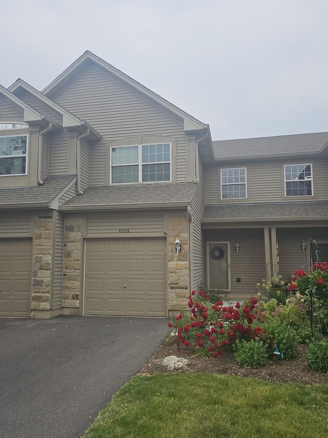 8314 Sierra Woods Ln, Carpentersville, IL 60110 - multi unit property featuring a garage, stone siding, driveway, and a porch