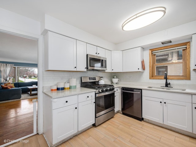 4048 W 105th St, Oak Lawn, IL 60453 - kitchen featuring stainless steel appliances, light wood-style flooring, decorative backsplash, and light countertops