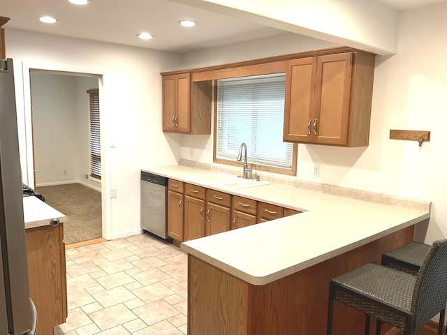 813 Junie Ct, Joliet, IL 60435 - kitchen featuring stainless steel dishwasher, brown cabinetry, a peninsula, a kitchen breakfast bar, and light countertops