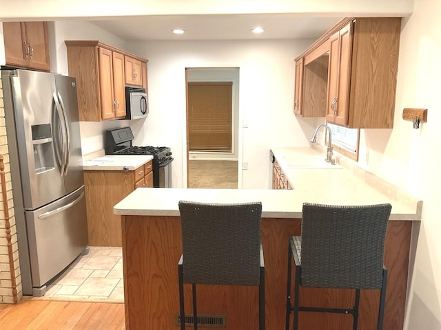 813 Junie Ct, Joliet, IL 60435 - kitchen featuring stainless steel refrigerator with ice dispenser, black gas stove, a peninsula, light countertops, and recessed lighting