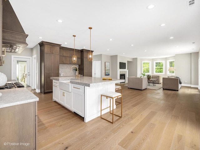 608 W 55th St, Hinsdale, IL 60521 - kitchen featuring custom exhaust hood, a sink, open floor plan, recessed lighting, and light wood finished floors