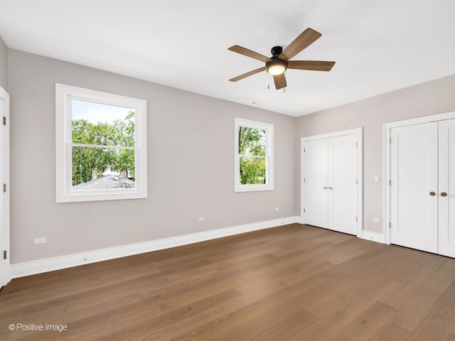 608 W 55th St, Hinsdale, IL 60521 - unfurnished bedroom featuring wood finished floors, multiple closets, baseboards, and a ceiling fan