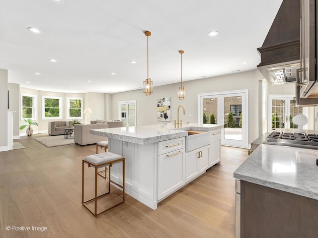 608 W 55th St, Hinsdale, IL 60521 - kitchen featuring a sink, white cabinetry, light wood-type flooring, recessed lighting, and a kitchen island with sink