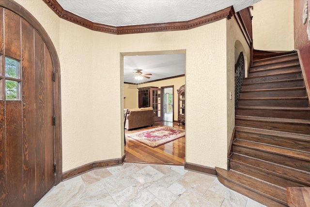 236 Country Club Rd, Chicago Heights, IL 60411 - foyer entrance with a textured wall, arched walkways, stairs, ornamental molding, and baseboards