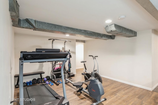 workout area featuring wood finished floors and recessed lighting
