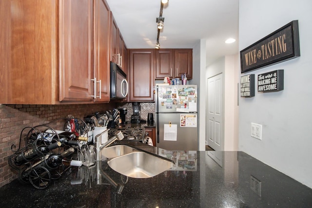 3900 N Pine Grove Ave Unit 203, Chicago, IL 60613 - kitchen with stainless steel appliances, dark stone countertops, backsplash, rail lighting, and a sink