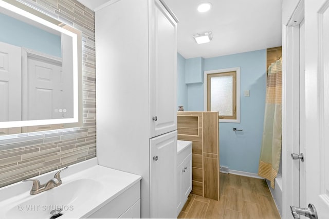17124 Langley Ave, South Holland, IL 60473 - bathroom with vanity, backsplash, baseboards, wood finished floors, and shower / bathtub combination with curtain
