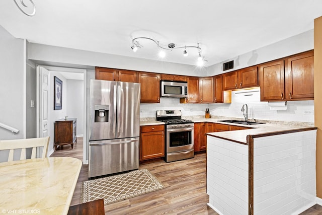 17124 Langley Ave, South Holland, IL 60473 - kitchen featuring appliances with stainless steel finishes, a sink, light wood-type flooring, and tasteful backsplash