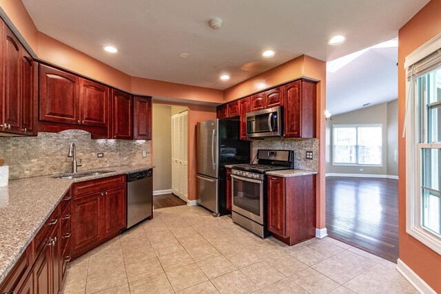 79 Willow Pkwy, Buffalo Grove, IL 60089 - kitchen featuring appliances with stainless steel finishes, a sink, healthy amount of natural light, backsplash, and vaulted ceiling