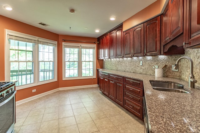79 Willow Pkwy, Buffalo Grove, IL 60089 - kitchen with a sink, stainless steel stove, backsplash, dark stone counters, and light tile patterned flooring