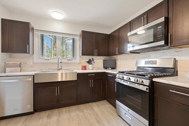 228 Oriole Rd, Matteson, IL 60443 - kitchen featuring stainless steel appliances, a sink, light wood-style flooring, and backsplash